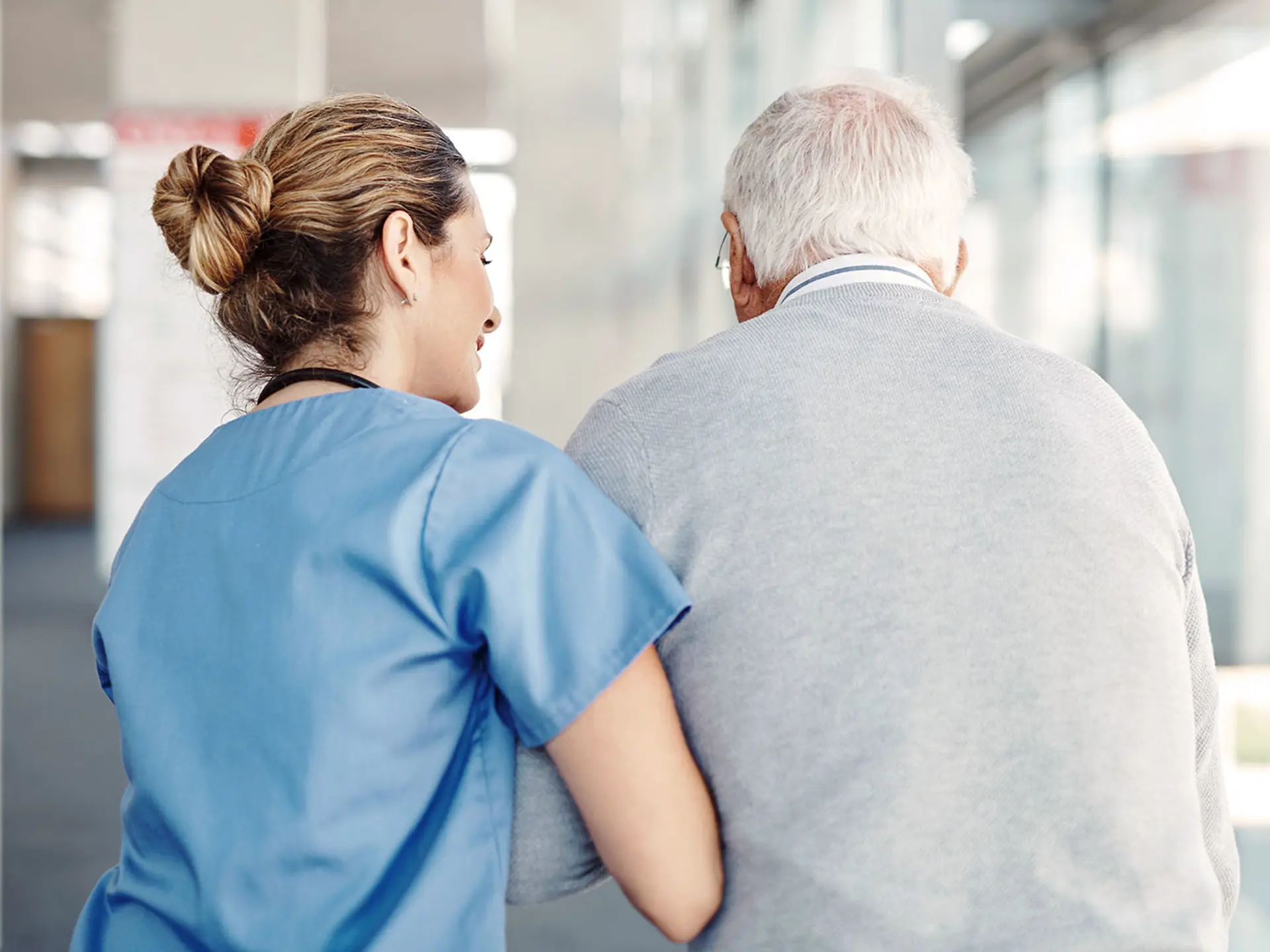 Sjuksköterska som går med patient