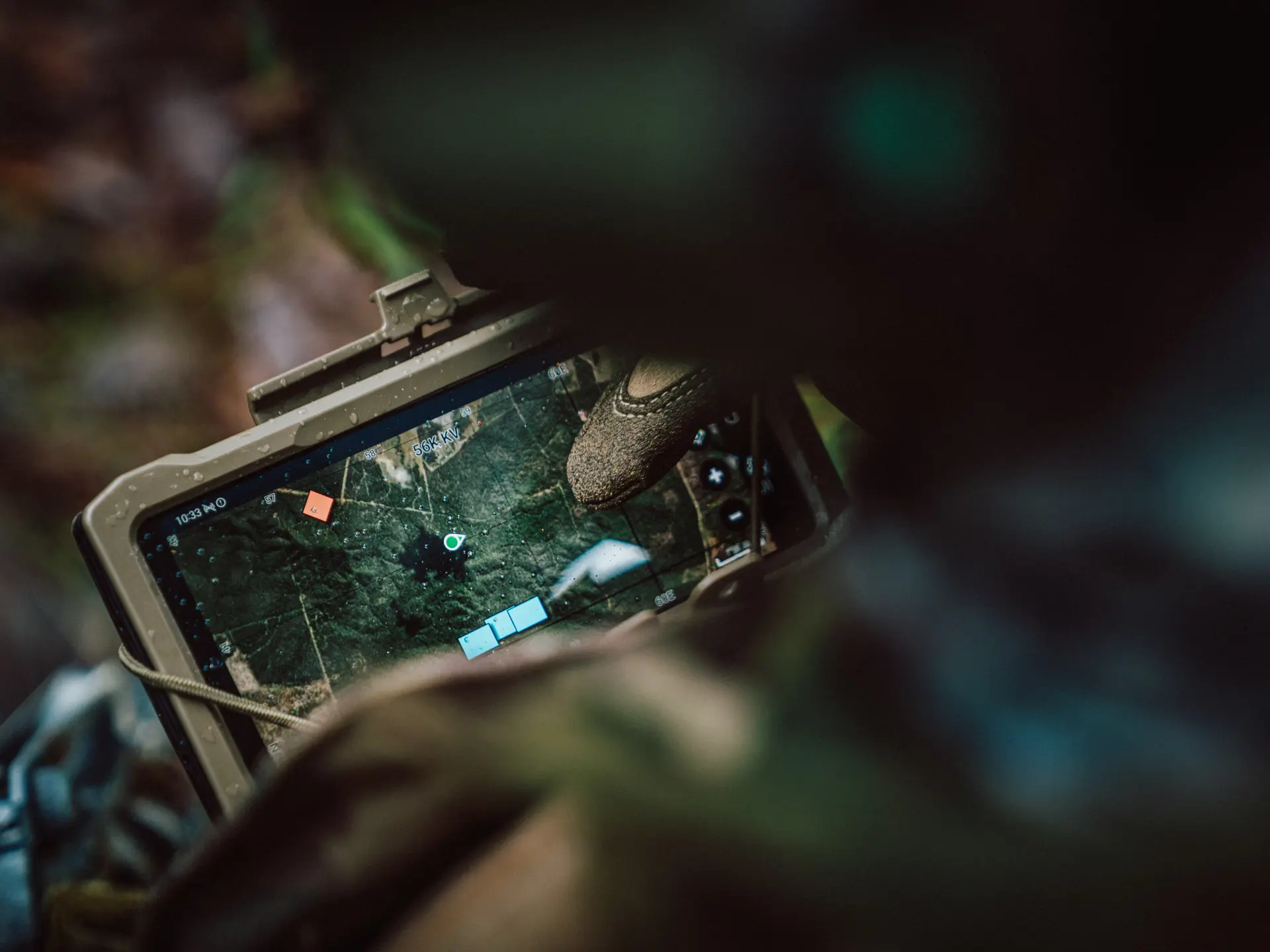Soldat bedient ein robustes Tablet mit dem SitaWare Frontline Fire Support-Modul, das eine taktische Karte und Zielmarkierungen anzeigt.