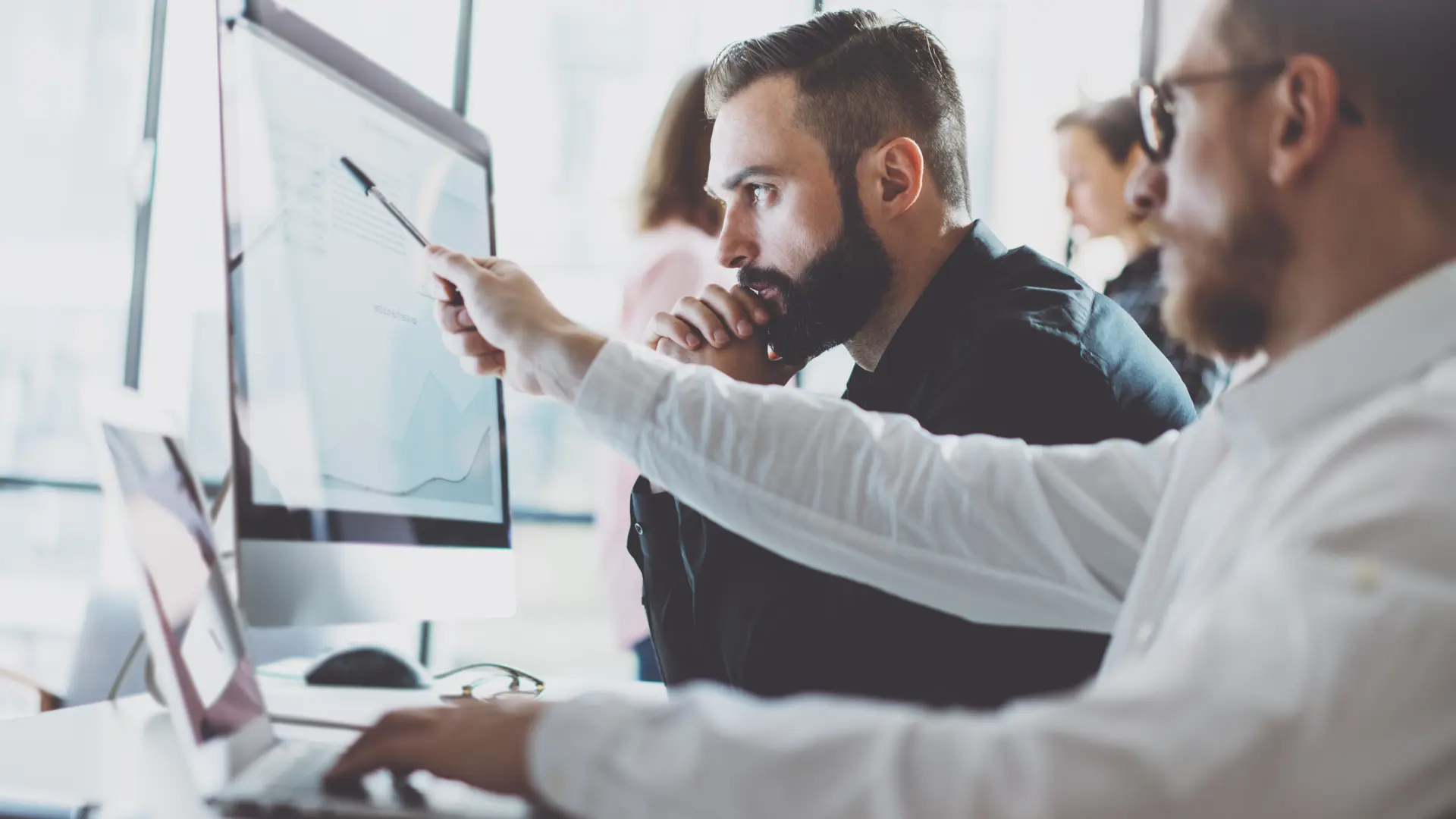 To mænd analyserer data på computer