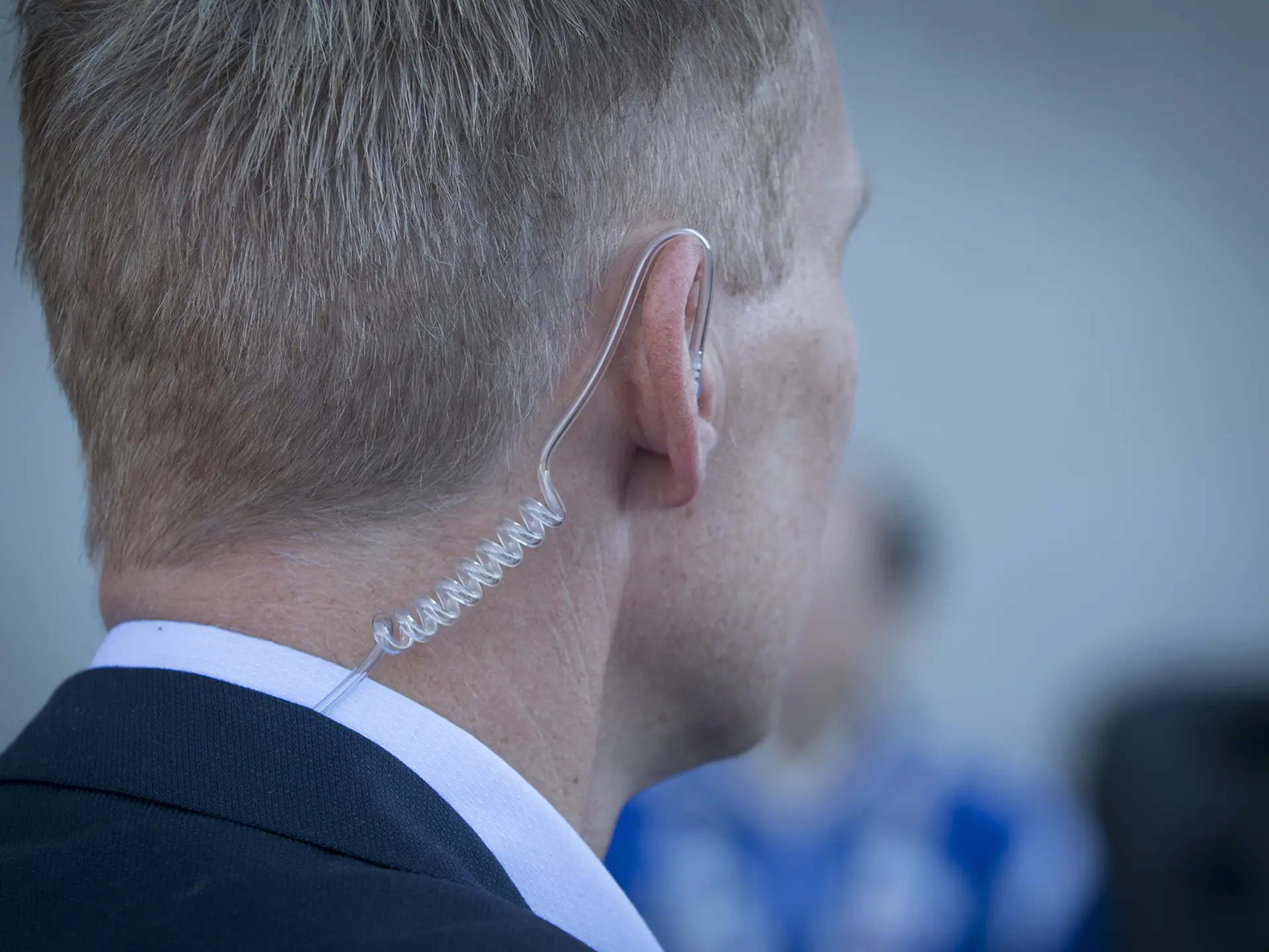 Close-up of a security professional wearing a clear acoustic earpiece used for discreet communication.