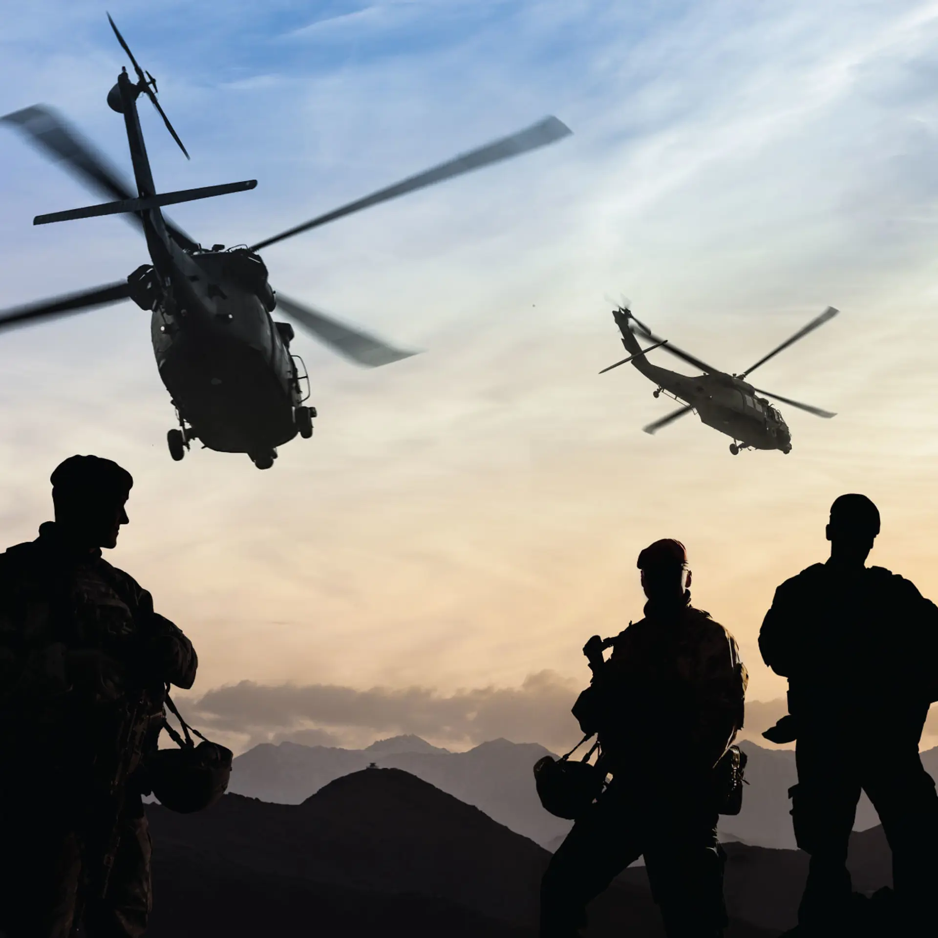 Helicopters flying above soldiers in shadow