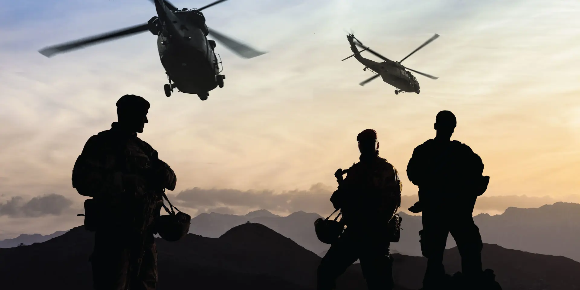 Helicopters flying above soldiers in shadow