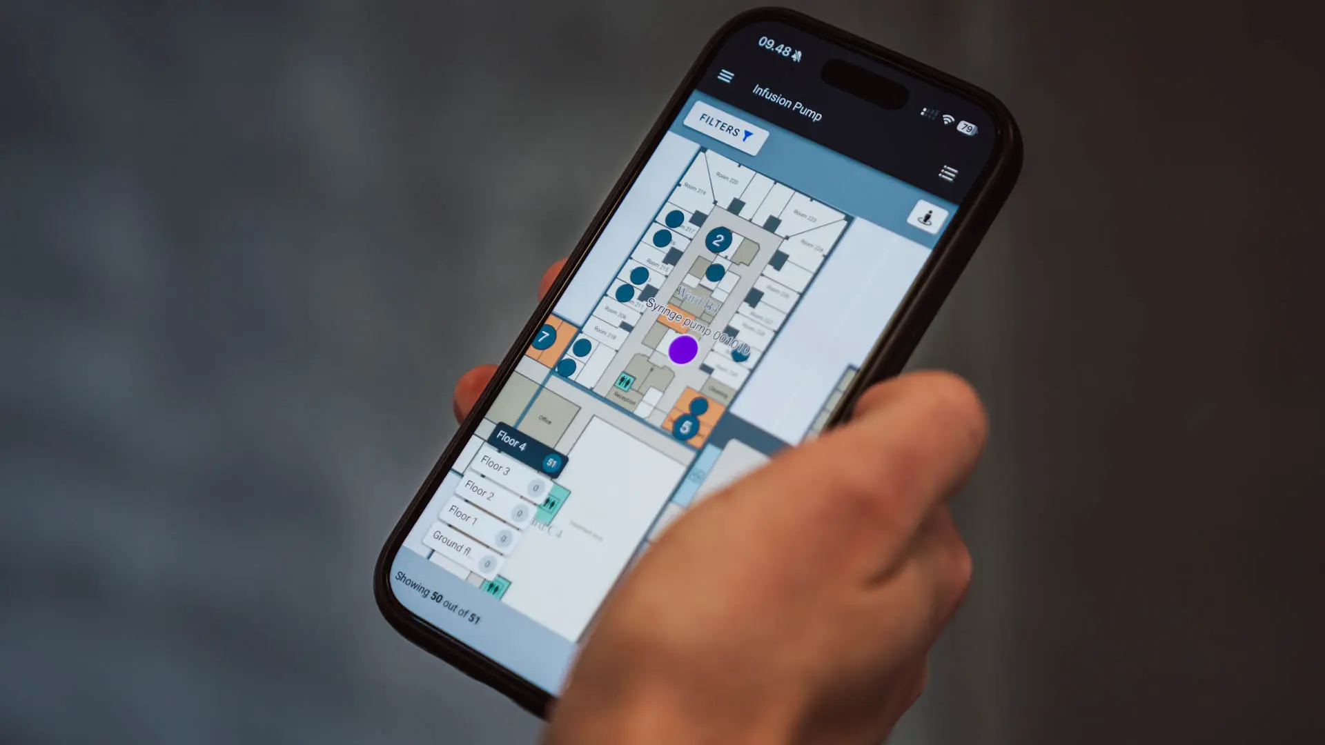 Mobiltelefon viser interaktivt hospitalsgulvkort med sporing af medicinsk udstyr og søgefunktion