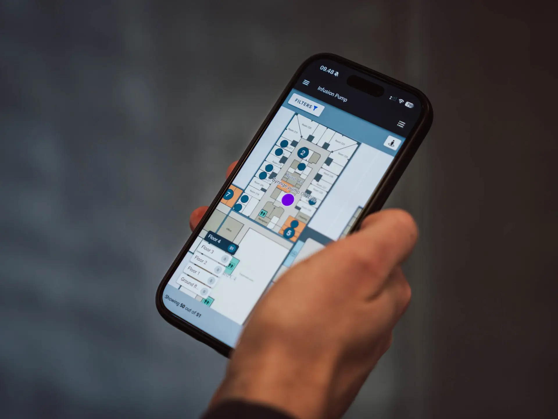 Mobile phone displaying interactive hospital floor map with medical equipment tracking and search functionality