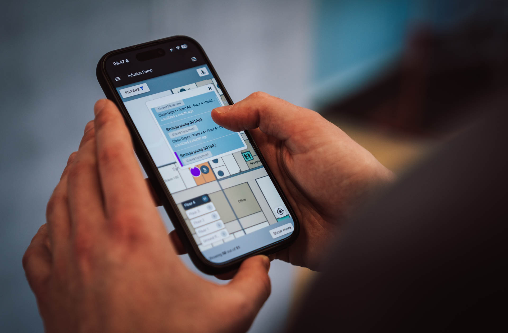 Healthcare professional using mobile app to search and locate infusion pumps and medical equipment on hospital floor plan
