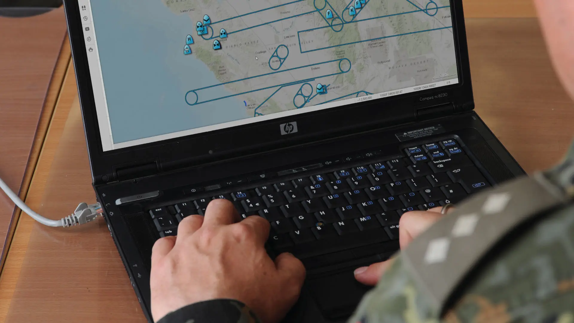 Soldier sitting with laptop with SitaWare Headquarters on the screen