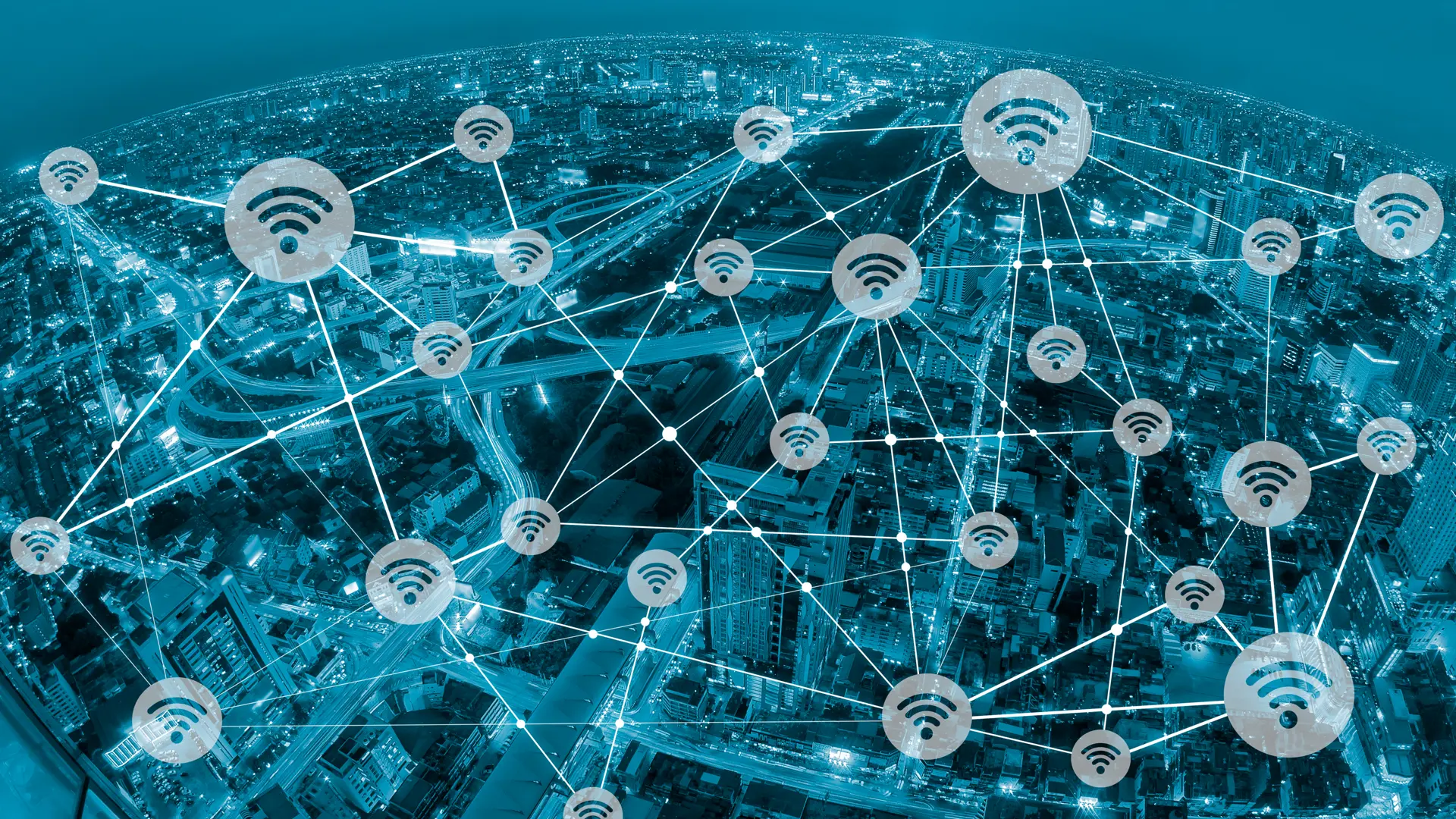 Aerial view of a city overlaid with connected wireless network icons, illustrating a smart city with digital connectivity, IoT infrastructure, and data-driven urban networks.