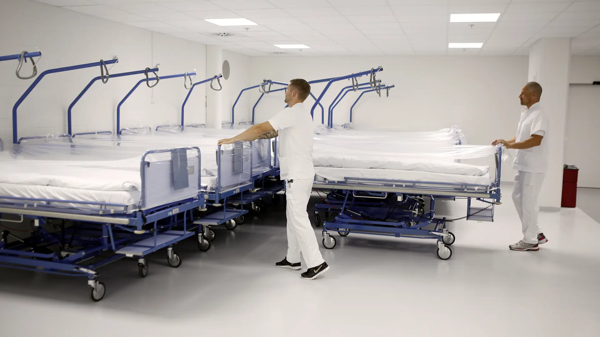 Hospital porters preparing clean beds in a sterile environment, highlighting how equipment tracking ensures medical devices are available, maintained, and compliant for patient safety.