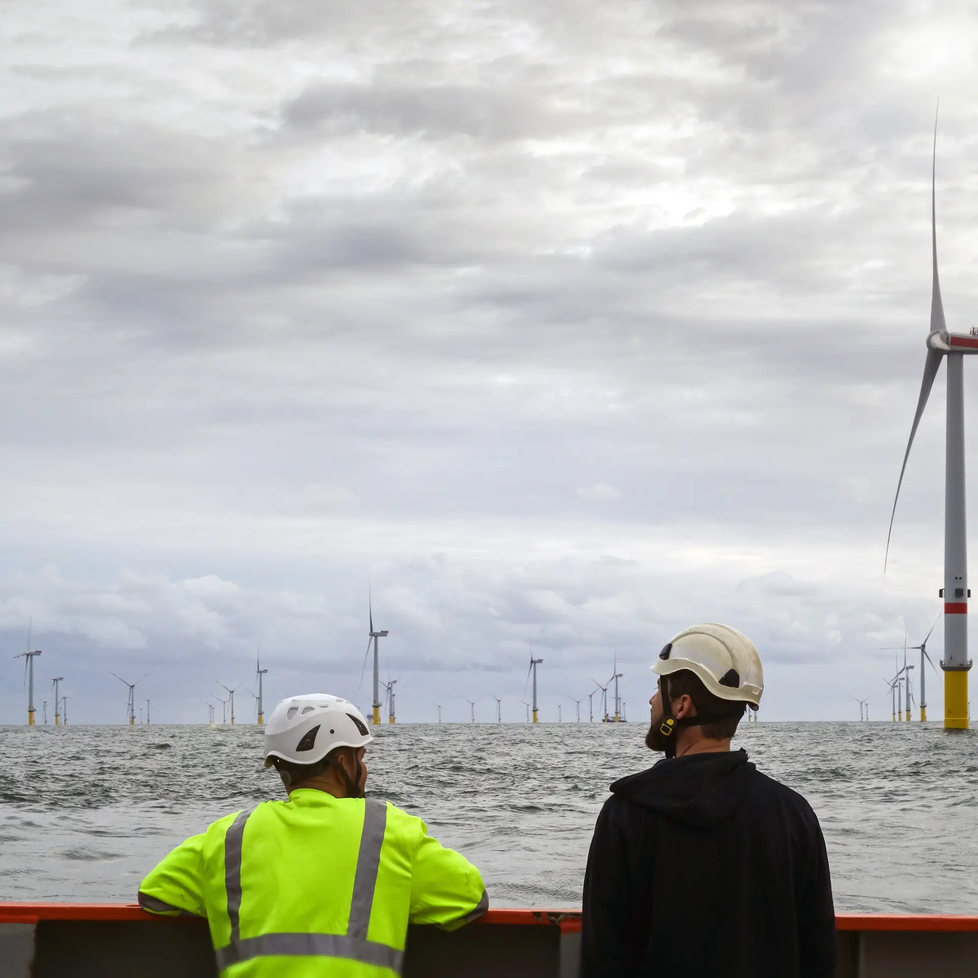 Two operators staring at an offshore wind farm