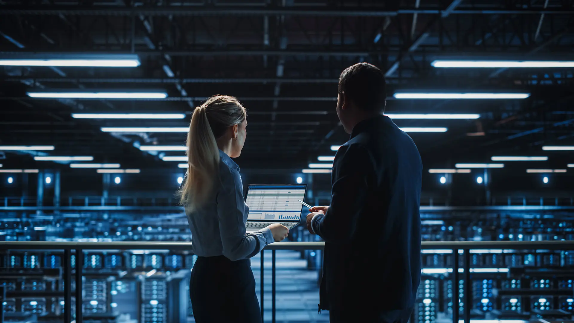 Data Engineers Talking In Front Of Server Farm