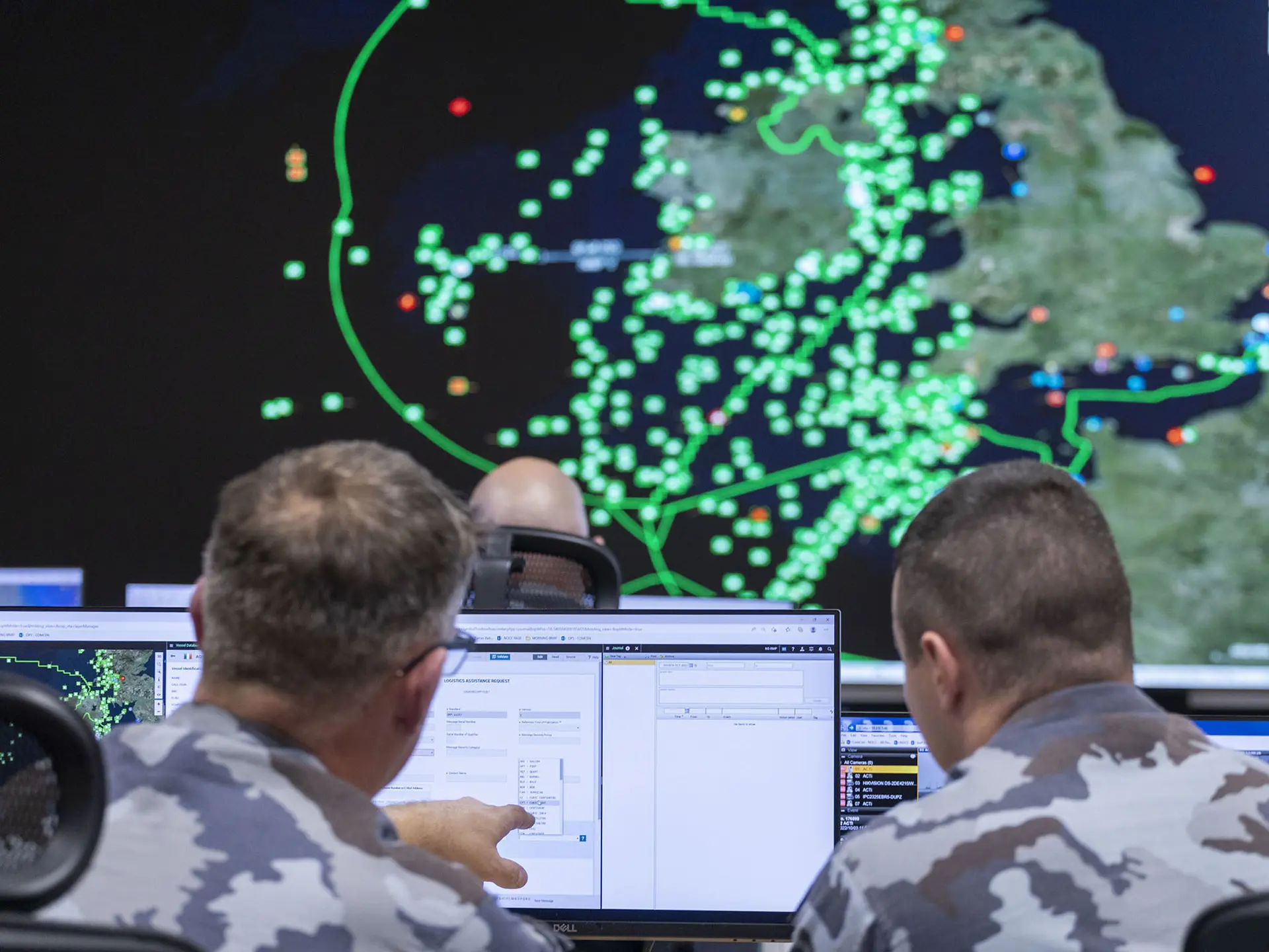 Two men in the military looking at screen