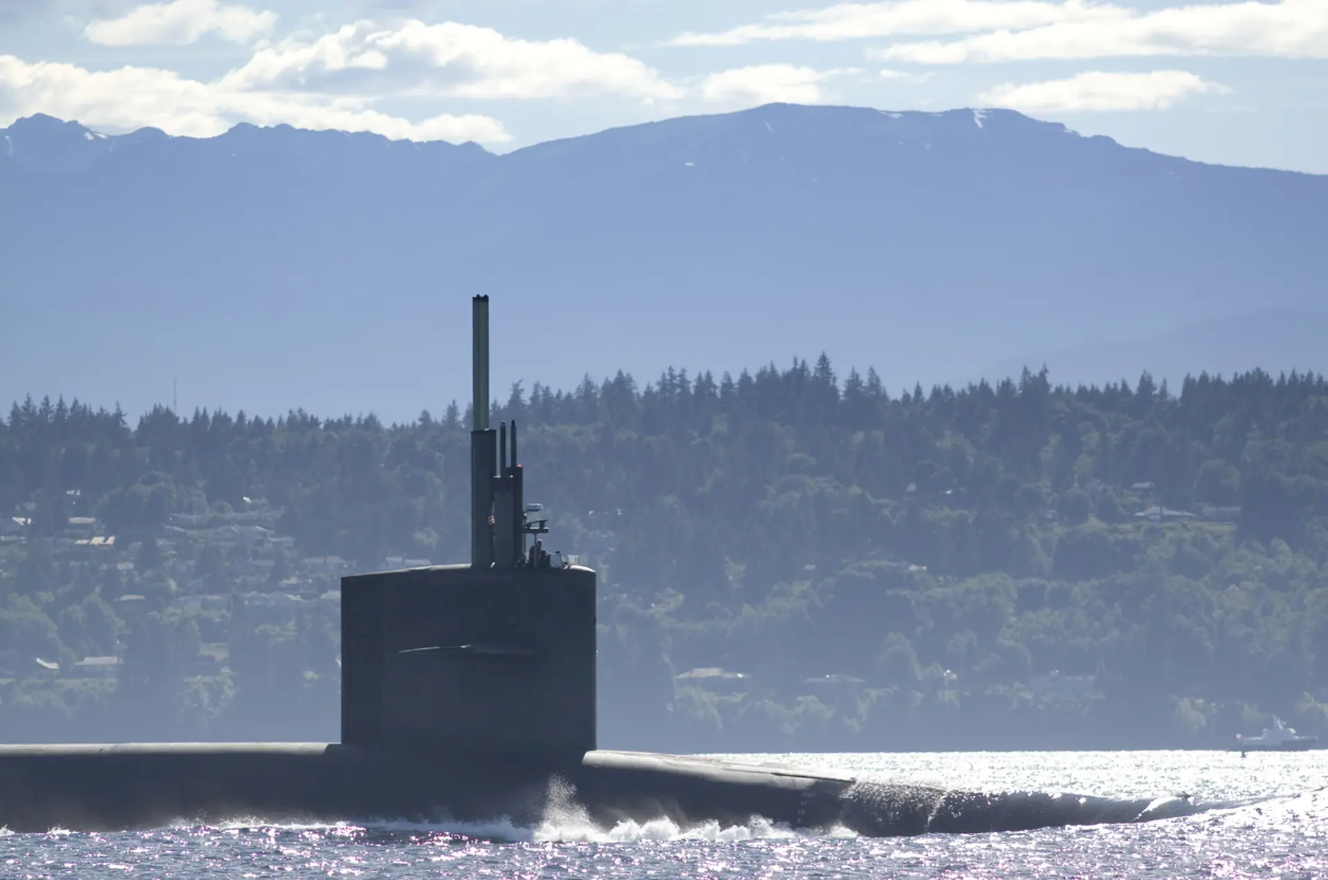 USS Alaska submarine surfacing with mountains in the horizon
