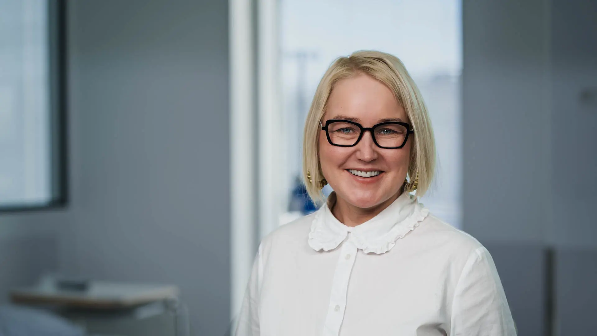 Portrait of Suvi Forss, Service Director at Tampere University Hospital, smiling in professional attire.